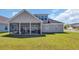 Back exterior view showcasing the screened-in porch and well-maintained lawn at 1512 Virginia Pine Dr., Longs, SC 29568