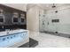 Modern bathroom with a jacuzzi tub, glass enclosed shower, and sleek black and white design at 1559 Old Tram Rd., Little River, SC 29566