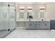 Elegant bathroom with marble floors, gray cabinetry, framed mirrors, and a glass shower at 1559 Old Tram Rd., Little River, SC 29566
