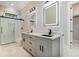 Bathroom showcasing gray vanity, black fixtures, framed mirrors, and glass shower door at 1559 Old Tram Rd., Little River, SC 29566