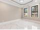 A bedroom with marble floors, two windows with black trim, and trey ceiling at 1559 Old Tram Rd., Little River, SC 29566