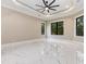 A bright and airy bedroom with high ceilings, a ceiling fan, and large windows showcasing the outside at 1559 Old Tram Rd., Little River, SC 29566
