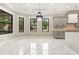 A spacious dining room area with bright marble floors, large windows, and a stylish modern chandelier at 1559 Old Tram Rd., Little River, SC 29566