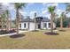 Striking home features a white exterior with black accents, landscaped yard, and inviting walkway to the front door at 1559 Old Tram Rd., Little River, SC 29566