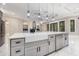 Kitchen island features a farm sink with gray cabinets, marble counters, and stainless steel dishwasher at 1559 Old Tram Rd., Little River, SC 29566