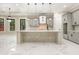 A bright kitchen features a large island, modern pendants, gray cabinets, and white marble countertops at 1559 Old Tram Rd., Little River, SC 29566