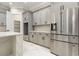 Kitchen with stainless steel refrigerator, gray cabinets, marble counters, and access to walk-in pantry at 1559 Old Tram Rd., Little River, SC 29566