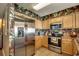 Modern kitchen with stainless steel appliances, wood cabinets, and striking floral wallpaper at 1625 S Ocean Blvd. # 1604, North Myrtle Beach, SC 29582