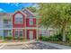 Charming two-story townhome with red siding, manicured landscaping, and inviting front entrance at 1631 Low Country Pl. # E, Myrtle Beach, SC 29577