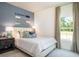 Cozy bedroom features a large window for natural light, blue accent wall and decorative oars at 166 Waterloo Sunset Dr., Longs, SC 29568