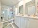 Well-lit bathroom with double vanity, mirrors, and a glass-enclosed shower at 1856 Melville Ct., Little River, SC 29566