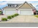 Charming home featuring a spacious two-car garage, adorned with American flags, and a well-maintained front yard at 1856 Melville Ct., Little River, SC 29566