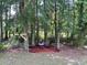 Wooded backyard featuring a fire pit area with mulch, several trees, and string lights for evening enjoyment at 190 Hamilton Way, Conway, SC 29526