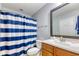A full bathroom with blue and white striped shower curtain, wood vanity, and a framed mirror at 190 Hamilton Way, Conway, SC 29526