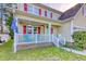 Charming front porch with a cozy seating area, white railings, brick base, and manicured landscaping at 190 Hamilton Way, Conway, SC 29526