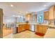 A kitchen featuring tile floors, warm wood cabinets, and stainless steel appliances, open to the dining area at 190 Hamilton Way, Conway, SC 29526