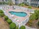 Aerial view of the community pool with lounge chairs and tables, surrounded by well-maintained landscaping at 2000 Cross Gate Blvd. # 104, Surfside Beach, SC 29575