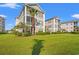 A well-maintained condo building with a sprawling green lawn and mature landscaping at 2000 Cross Gate Blvd. # 104, Surfside Beach, SC 29575