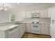 Efficient kitchen featuring white cabinets, countertops and appliances and a wood floor at 2000 Cross Gate Blvd. # 104, Surfside Beach, SC 29575