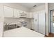 Bright kitchen featuring white cabinets, countertops, and appliances with wood-style flooring at 2000 Cross Gate Blvd. # 104, Surfside Beach, SC 29575