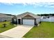 Brick and vinyl siding home with two-car garage, landscaping, a large driveway, and fenced backyard at 203 Golden Bear Circle, Longs, SC 29568