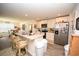 Open kitchen with white cabinetry, stainless steel appliances, and a breakfast bar overlooking the dining area at 203 Golden Bear Circle, Longs, SC 29568