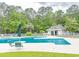 Community pool area with chairs and umbrellas surrounded by mature trees at 227 Pinehurst Ln. # 6D, Pawleys Island, SC 29585