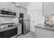 Modern kitchen featuring stainless steel appliances, granite countertops, and light gray cabinets at 2409 Seabreeze Pl., Myrtle Beach, SC 29577