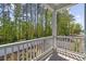 Inviting covered porch with white railings overlooking lush green trees and landscaping at 2409 Seabreeze Pl., Myrtle Beach, SC 29577