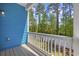 Charming porch with light blue siding and white railings offering tranquil views of greenery at 2409 Seabreeze Pl., Myrtle Beach, SC 29577