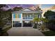 Charming elevated beach home featuring a spacious covered parking area, blue accents, and a cozy front porch at 2602 Holly Dr., North Myrtle Beach, SC 29582