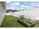 This backyard features a charming garden bed and a well-maintained white fence for added privacy at 305 Blue Rock Dr., Longs, SC 29568
