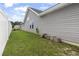 Exterior view of the home, showcasing the vinyl siding and a garden hose neatly hanging near the foundation at 305 Blue Rock Dr., Longs, SC 29568