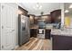 Well-lit kitchen featuring stainless steel appliances, dark wood cabinets, and wood-look flooring at 305 Blue Rock Dr., Longs, SC 29568