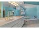 Bright bathroom featuring a double sink vanity and tub with tile surround and vintage gold hardware at 321 Heather Ct., Sunset Beach, NC 28468