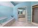 Light blue bathroom with a tub, shower, and mirrored closet doors and bright tiled floors at 321 Heather Ct., Sunset Beach, NC 28468