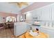 Bright kitchen with white cabinets, tiled backsplash, and breakfast area with decorative flooring at 321 Heather Ct., Sunset Beach, NC 28468