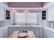 Bright kitchen with white cabinets, tiled countertops, and large window providing natural light at 321 Heather Ct., Sunset Beach, NC 28468