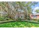 Brick home with lush green lawn and mature trees, creating a serene and inviting landscape at 356 Chapman Loop, Pawleys Island, SC 29585