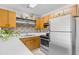 Well-lit kitchen featuring stainless appliances, wood cabinets, mosaic backsplash, and modern countertops at 3700 Golf Colony Lane # 18-G, Little River, SC 29566