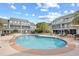 Serene pool setting with inviting lounge chairs, surrounded by lush landscaping and palm trees at 3700 Golf Colony Lane # 18-G, Little River, SC 29566