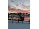 Tranquil sunset view of a lake with snow on the ground behind a black metal fence at 388 Carriage Lake Dr., Little River, SC 29566