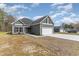 View of the exterior with a two-car garage, landscaped front yard, and green siding at 4010 Macks Rd, Aynor, SC 29511
