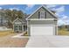 Charming home exterior featuring a two-car garage, landscaped front yard, and green siding at 4010 Macks Rd, Aynor, SC 29511