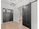 Bright foyer featuring a modern light fixture and a sliding barn door at 4016 Macks Rd, Aynor, SC 29511