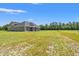 Expansive backyard with lush green grass and gray, one-story house, offering plenty of outdoor space and privacy at 4022 Macks Rd, Aynor, SC 29511