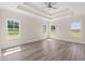 Bright bedroom with tray ceiling, ceiling fan, and three windows with field views at 4022 Macks Rd, Aynor, SC 29511