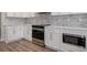 Close-up of modern kitchen with white cabinets, stainless steel appliances, and marble countertop at 4022 Macks Rd, Aynor, SC 29511
