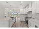 Well-equipped kitchen features an island, stainless steel appliances, white cabinetry, and hardwood floors at 4022 Macks Rd, Aynor, SC 29511