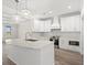 Modern kitchen features an island with a sink, stainless steel appliances, white cabinetry, and hardwood floors at 4022 Macks Rd, Aynor, SC 29511